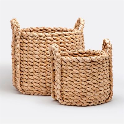 Three woven seagrass baskets in a light brown tone with two handles on each presented against a plain background showcasing their natural