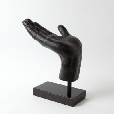 Bronze hand sculpture on a black pedestal, capturing an open gesture.