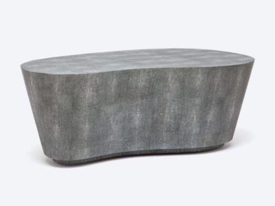 A sleek, kidney-shaped coffee table in a mid-century modern style, available in both sand and grey faux shagreen finishes.