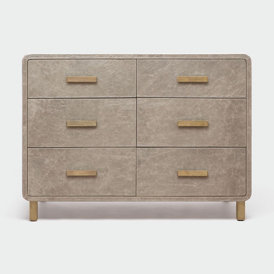 A beige leather dresser with curved edges three drawers open bottom linen interior antiqued gold metal feet also available in smoke or