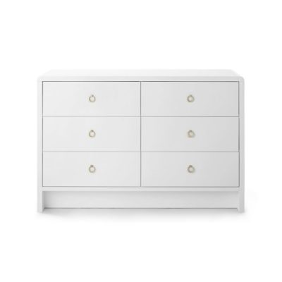 White dresser with six drawers and antique bronze ring pulls, displayed in a showroom setting.