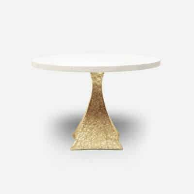 A round table with a golden, faux shagreen top and tapered aluminum base.