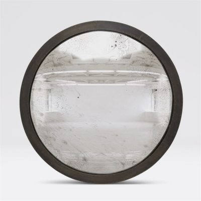 A round convex mirror with a dark antique brass frame featuring an intricate design and a dusty surface effect The mirror is