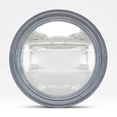 Round mirror with elegant gray frame reflecting spacious room interior.