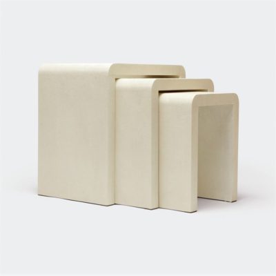 Three ivory faux shagreen nesting tables in a waterfall design, with two smaller tables placed behind the largest one.
