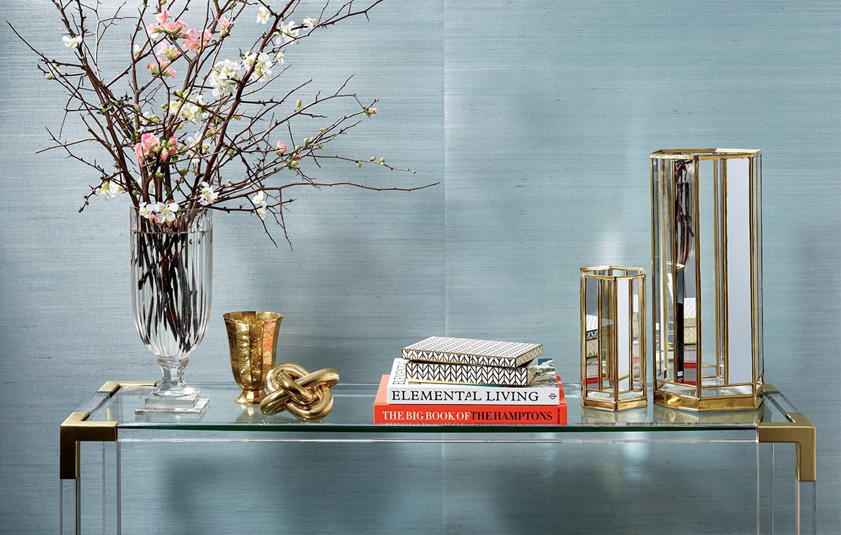 The image displays a modern minimalist interior design setting with a focus on a gold-touches-5 product A sleek contemporary glass table with
