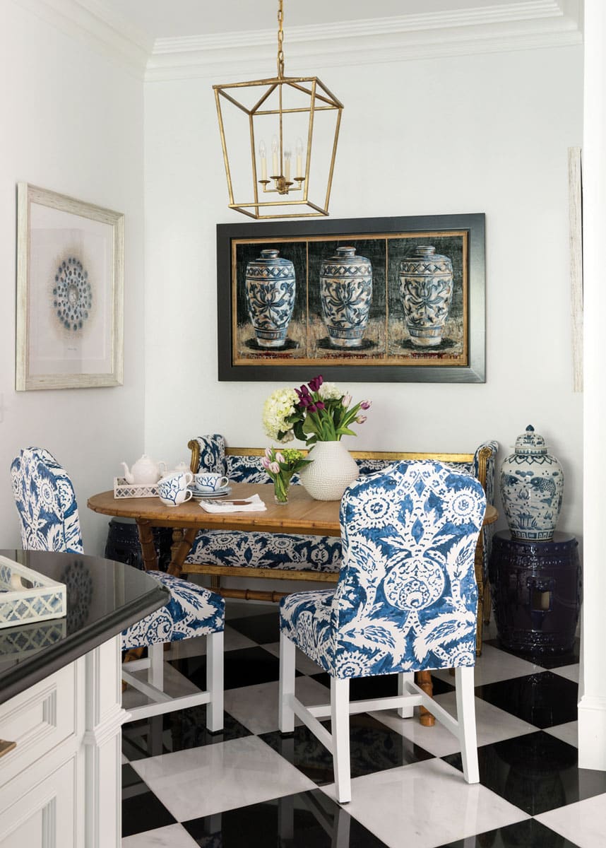 A spacious dining room with a large table and chairs featuring a blue and white patterned upholstery on the chairs and a