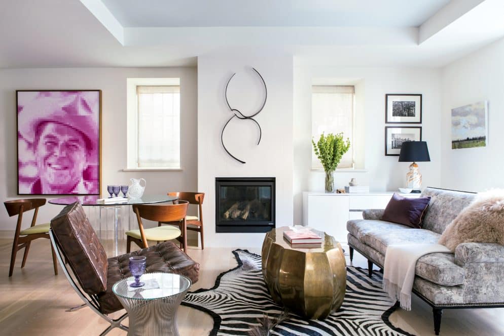A modern living room with a large window white walls and a rug on the floor The room features a fireplace a