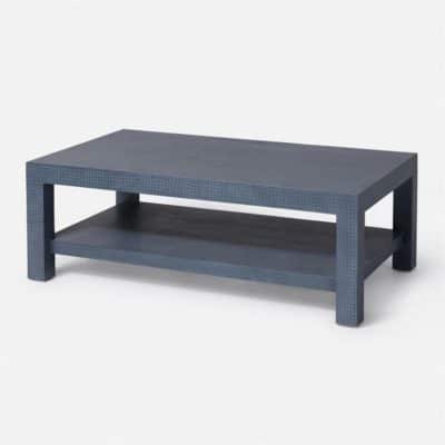 Woven faux leather coffee table with a blue distressed weave design featuring two shelves and a rectangular top set against a white