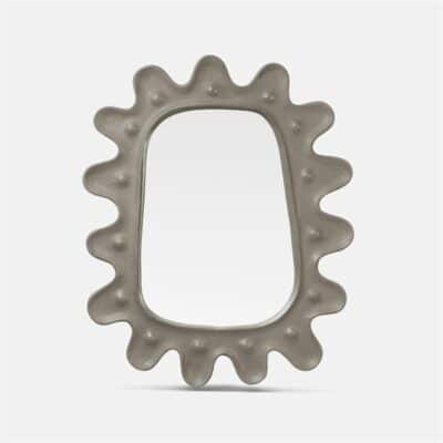 Dark gray starburst concrete mirror with a metal ring for hanging on an outdoor wall, showcasing its unique pattern and texture.