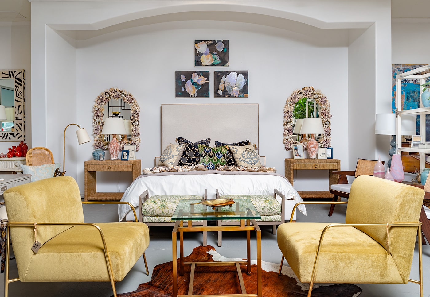 A well-decorated living room with a large, colorful rug, two yellow armchairs, and a wooden coffee table in the center.