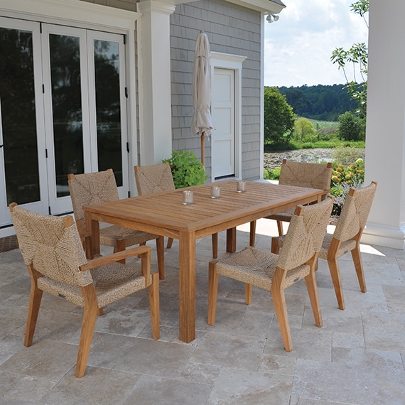 Outdoor teak and rope dining side chair, featuring a sturdy teak frame with woven all weather rope cushioning, suitable for outdoor use.