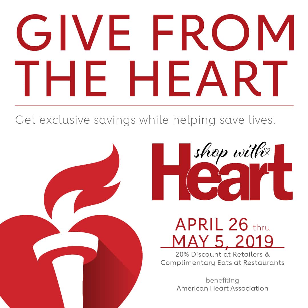 A red and white poster with a heart symbol in the center featuring a message that reads Give from the Heart at