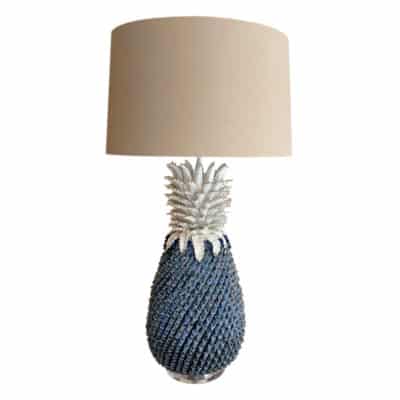 Large ceramic pineapple lamp with a blue patterned shade and lucite base.