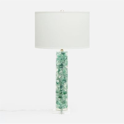 A lamp with a white shade and a clear resin base, adorned with green crystals, standing on a surface.