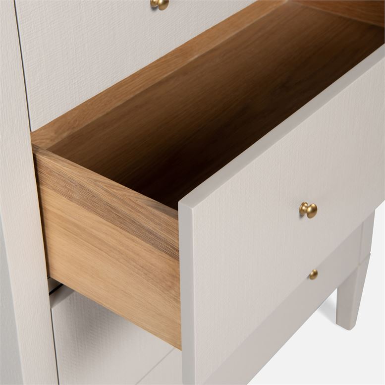 White and wooden tallboy dresser with eight drawers, showcasing a modern design with a clean finish.