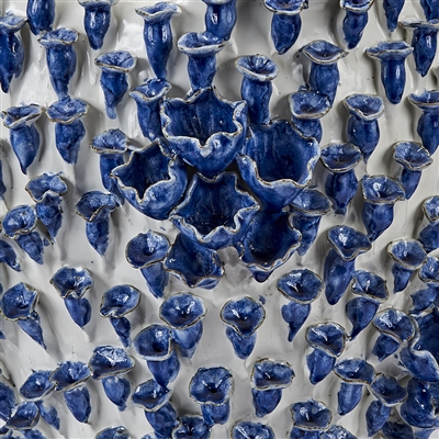 Blue and white ceramic vase with irregular forms, each varying in size and shape, displayed against a backdrop of similar items.