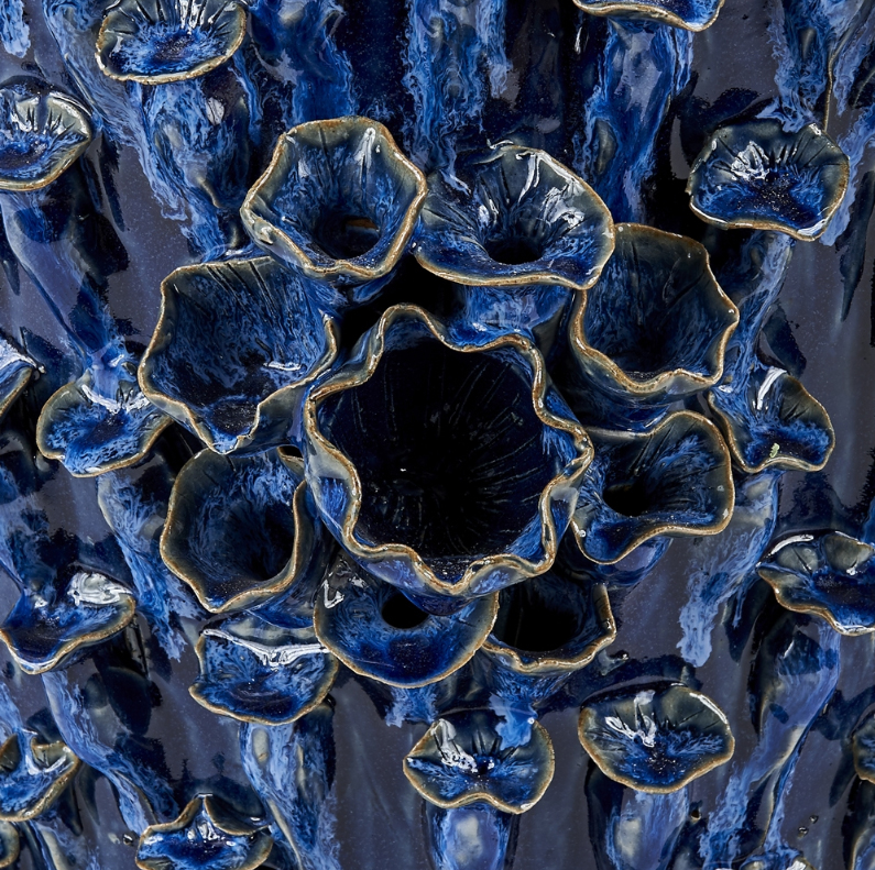 Large ornate irregularly shaped blue and white ceramic vase with varying size and shape showcasing intricate details that mimic coral-like patterns available
