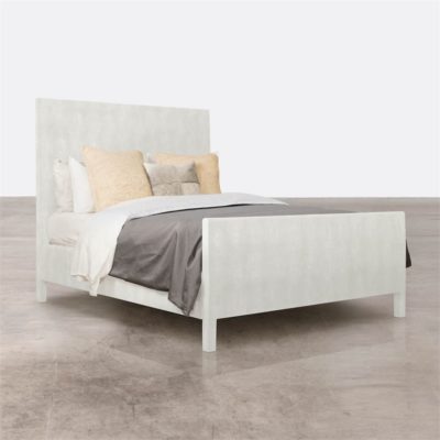 Large, white paneled bed with tufted headboard in a room.