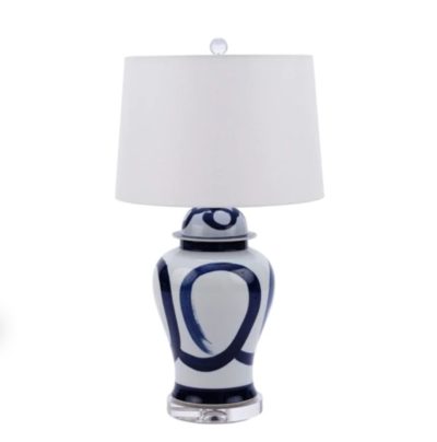 Blue and white swirl brushstroke table lamp with a lucite base, sitting on a surface.