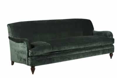 A dark blue velvet sofa with a tufted back and legs showcasing a luxurious and elegant style presented in a studio setting