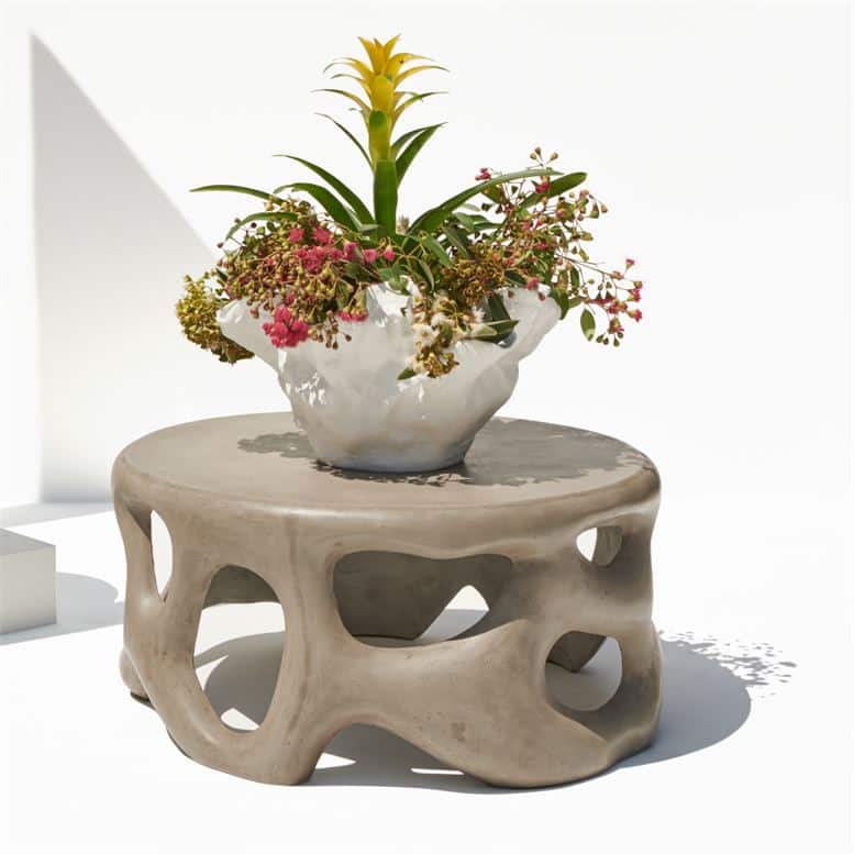 Outdoor Sculpted Concrete Coffee Table with Vase of Flowers on top.