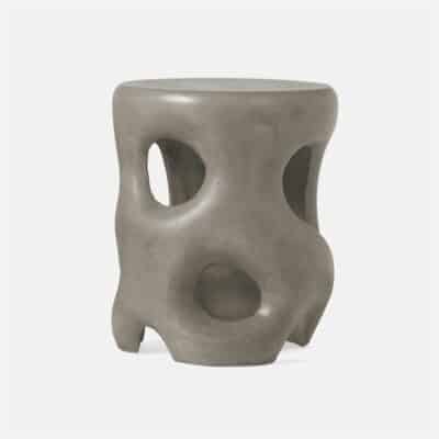 Outdoor concrete stool with sculpted design and holes for sitting.
