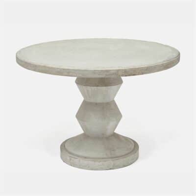 Round light gray concrete dining table with zig zag base and natural distressing.