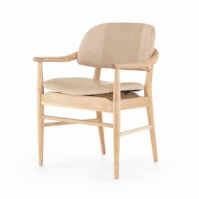 Brown mid-century modern dining chair with light tan leather seat featuring sloped arms and cone tapered legs in a vintage white wash
