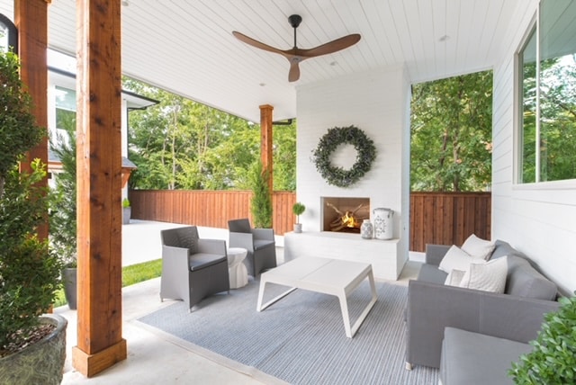 This is a picture of a modern outdoor patio area The space features a wooden deck with a pergola a white wall