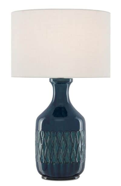 A blue ceramic table lamp with etched pattern and white drum shade.