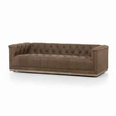 Dark brown leather sofa with tufted backrest and nailhead trim, set against a white background.