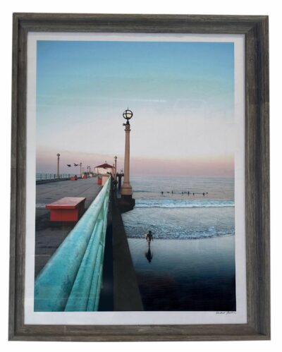 The image depicts an atmospheric scene at a pier during sunrise The photograph captures the tranquil beauty of the ocean meeting the