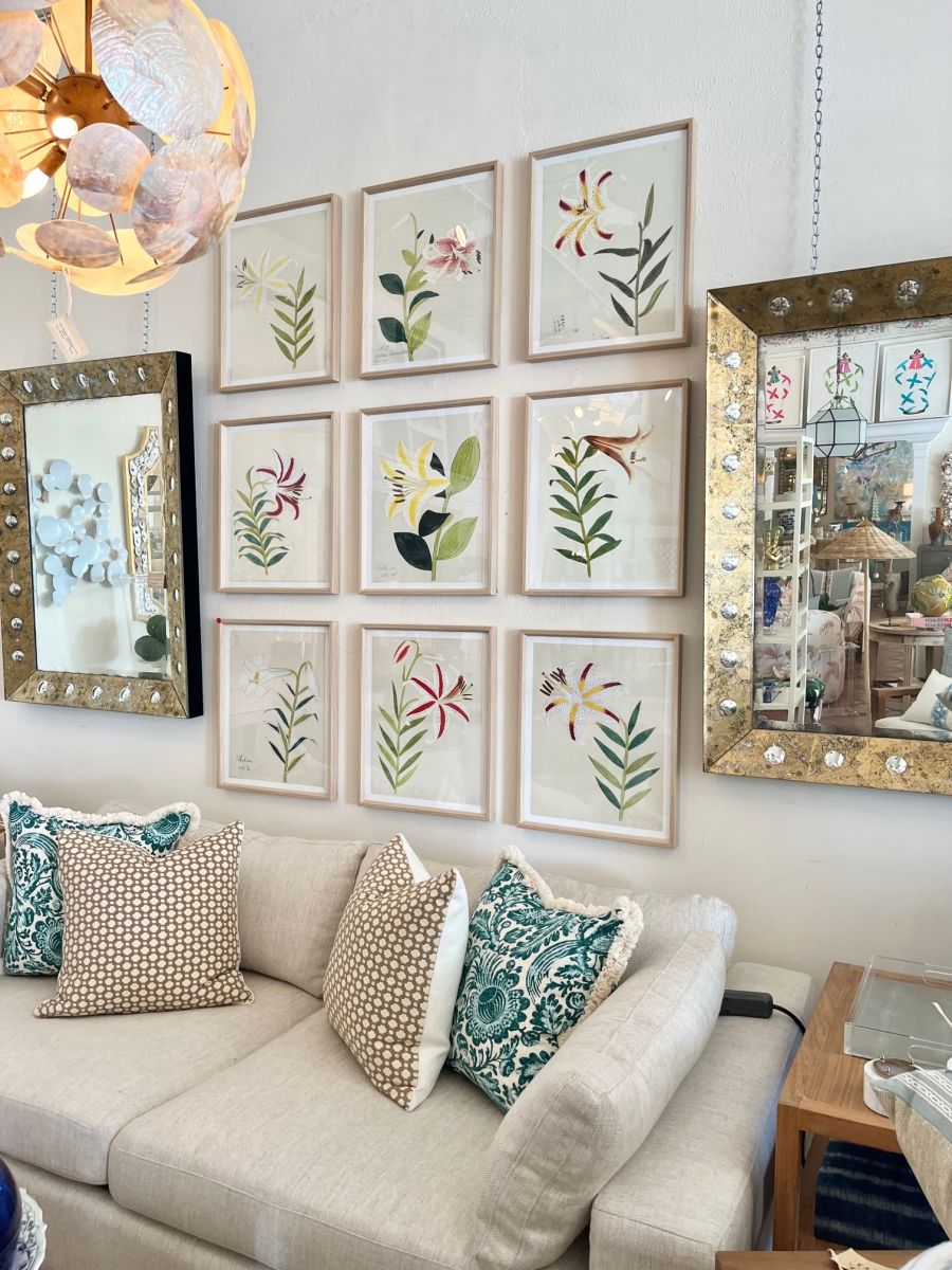 Vibrant Reproduction Prints of Coloured Lilies, each uniquely framed in oak, displayed on a white wall against a cozy couch.