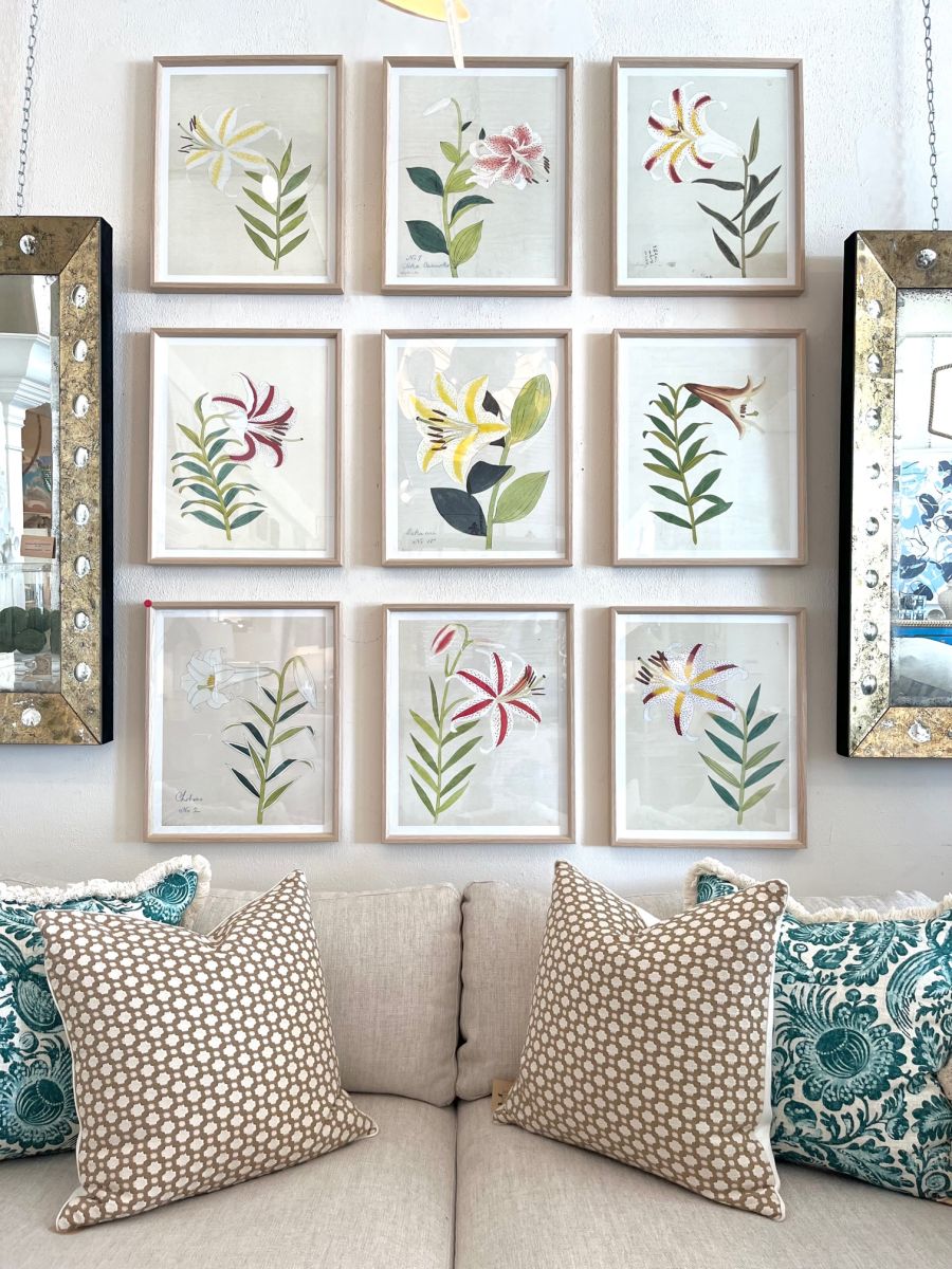 Nine framed reproduction prints featuring a collection of colorful lily arrangements, hung together as an art display against a white wall.