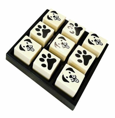 The image shows a collection of nine dog-themed Tic-Tac-Toe squares arranged in a grid placed on a black tray Each square features