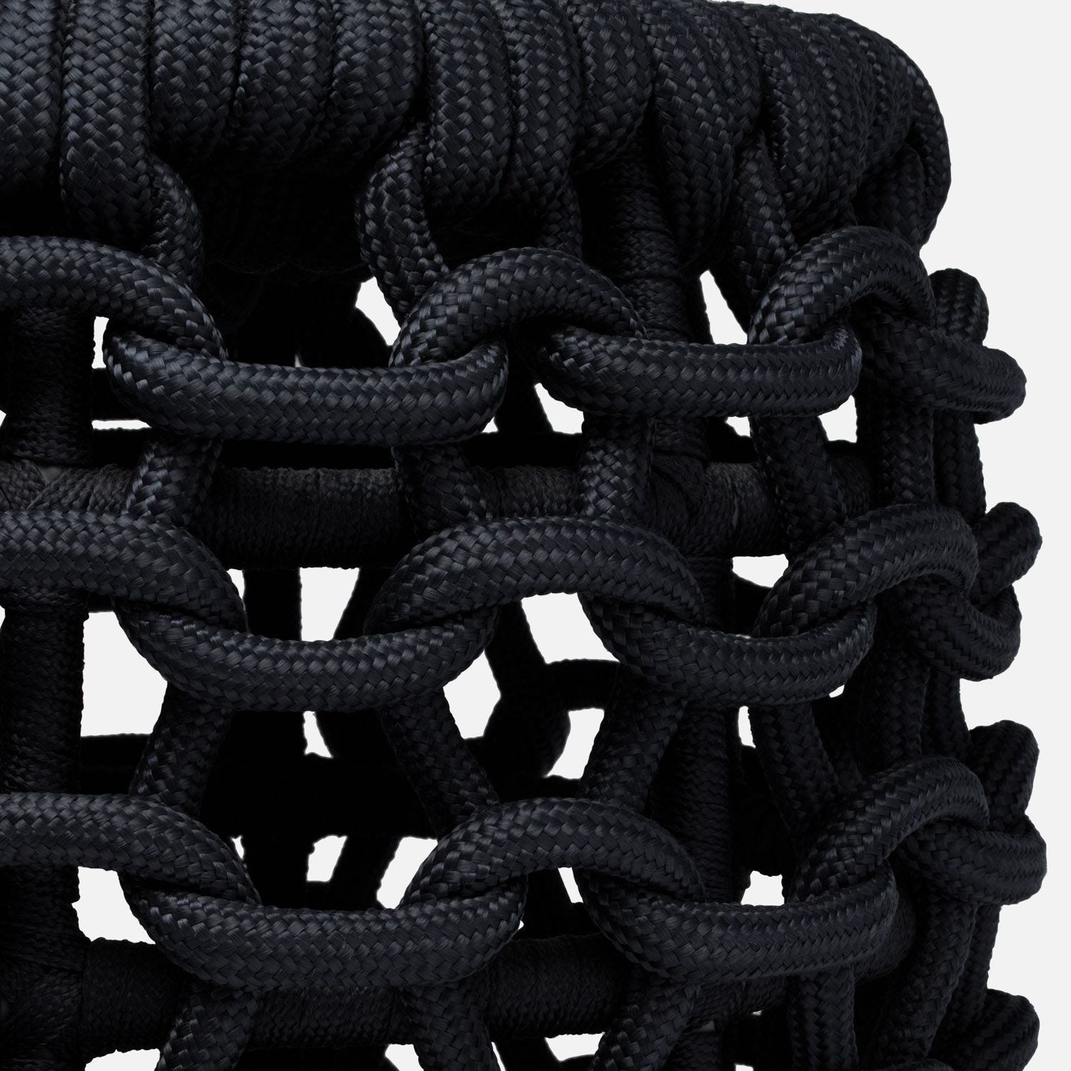 A cozy black rope chain link stool, part of an outdoor performance collection available in Azure, Dark Navy or Slate colors.