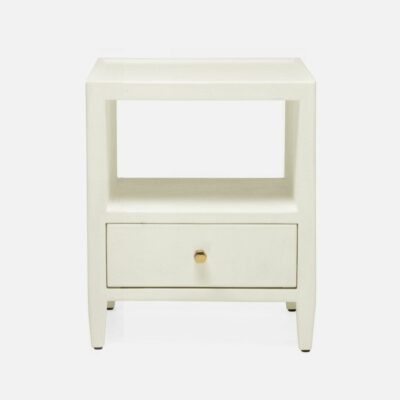 A small white side table with a bottom drawer featuring a top shelf over two drawers each adorned with gold-finished pulls The