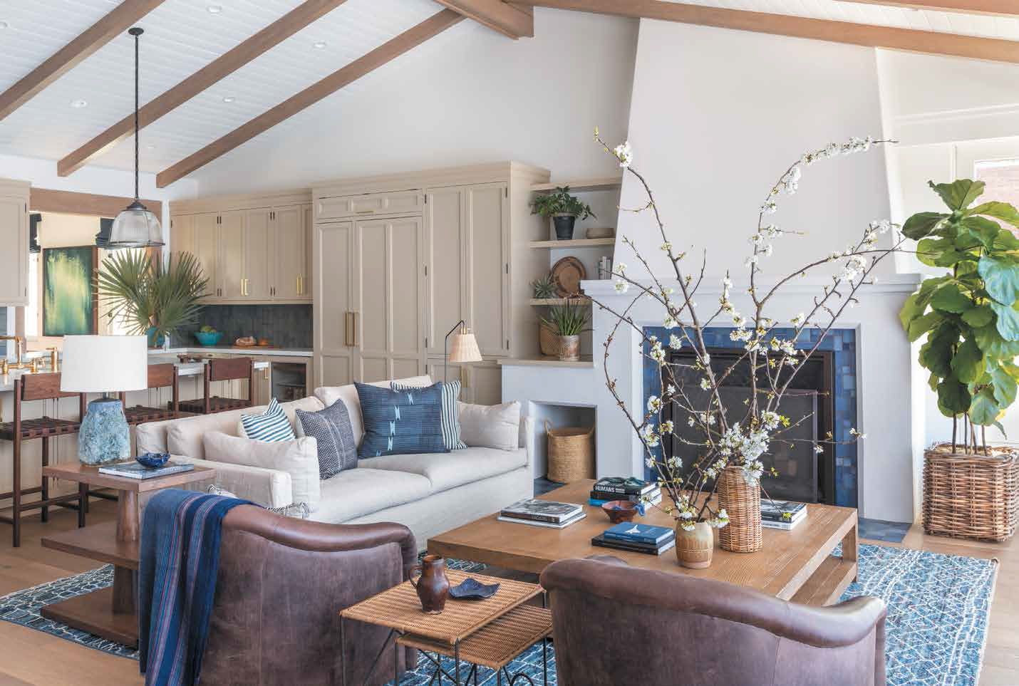 Modern living room with white walls, dark wood ceiling beams, and leather furniture.