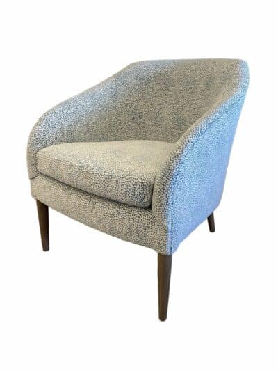 Stylish teal spotted fabric chair in a cozy living room setting.