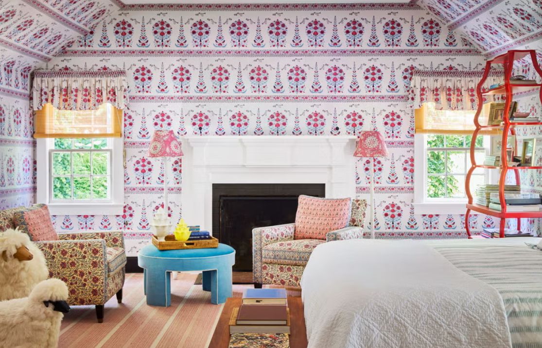 Bedroom with colorful floral wallpaper and cozy furnishings, showcasing an inviting atmosphere for relaxation.