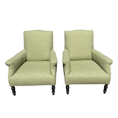 Pair of antique chairs with floral upholstery, rolled arms, and nailhead detail.