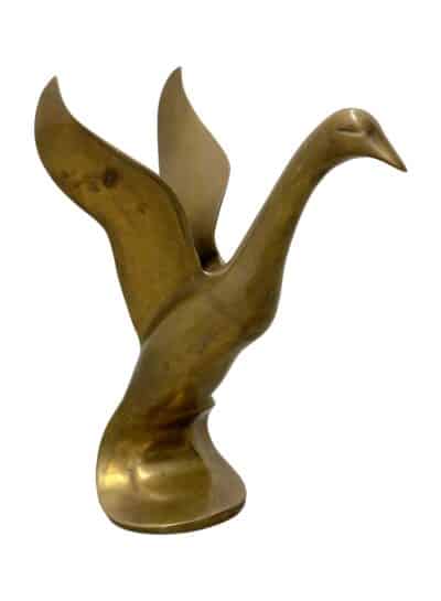 Brass duck sculpture in flight, vintage appeal.