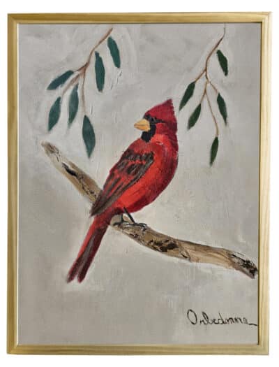 Cardinal perched on branch, vibrant red bird against green leaves on canvas, framed with golden edge.