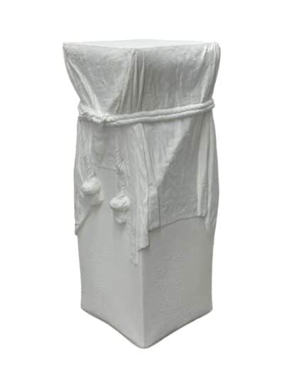 Hollywood Regency style plaster pedestal, featuring draped rope detail
