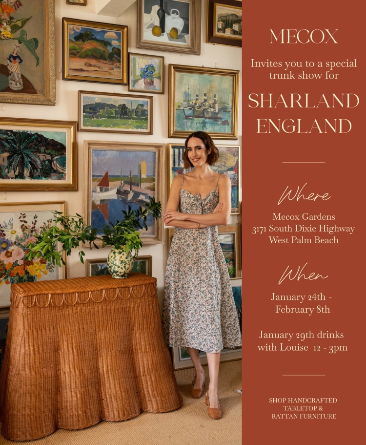Woman in floral dress standing in front of wall art.