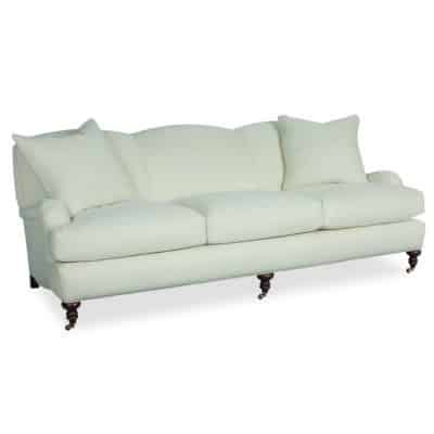 Classic sofa with English arm, brass casters, and rolled maple legs.
