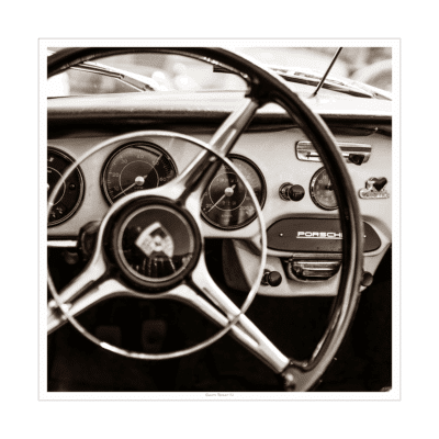 Close-up of vintage Porsche steering wheel with black frame in monochrome photograph.