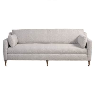 Bright blue geometric sofa with loose seat and back, accented by antique brass casters.