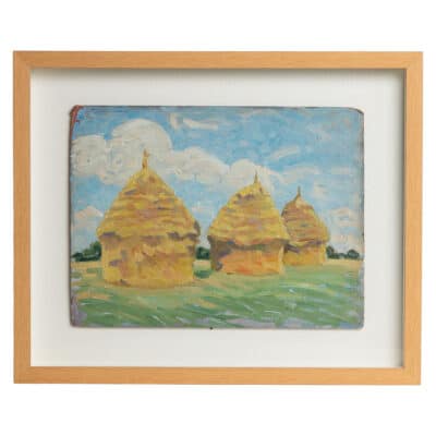 Close-up of framed painting featuring French Impressionist haystacks in field, mounted in shadow box.